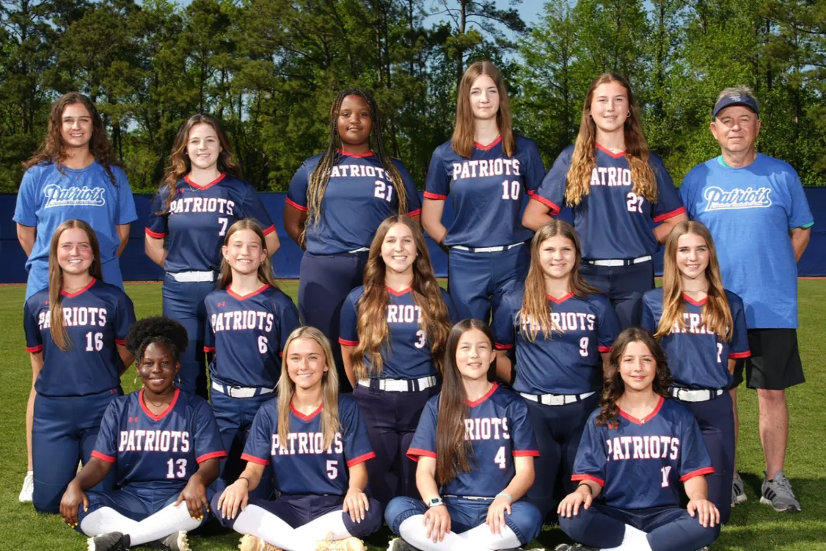 The varsity softball team and coaches on the field