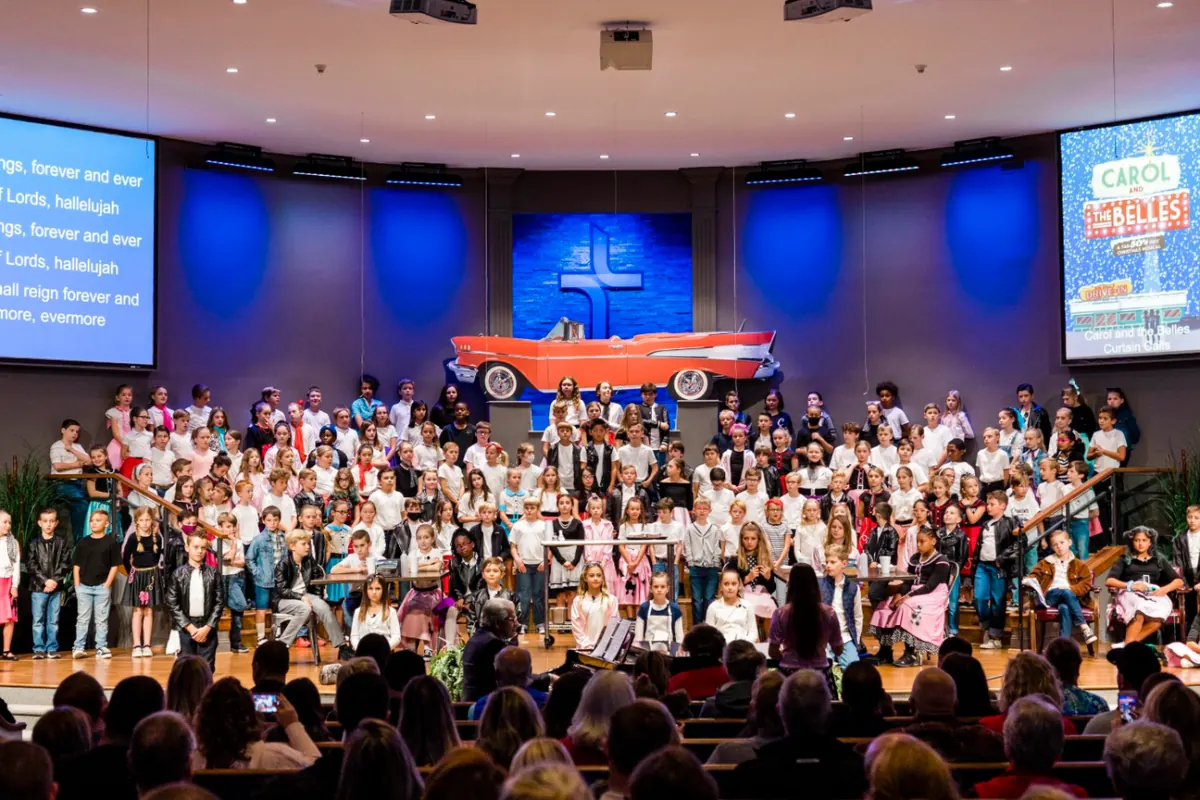 Elementary students performing a Christmas musical on stage for a full audience