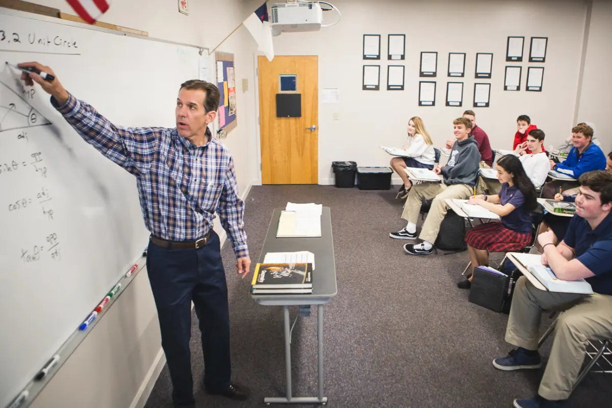 A math teacher explaining the unit circle at the whiteboard to his class