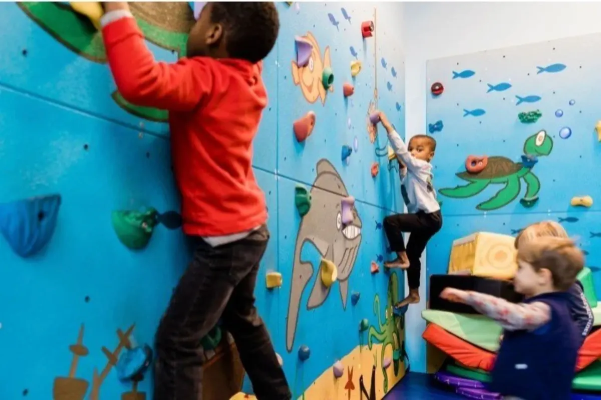 Preschoolers climbing an ocean-themed indoor climbing wall