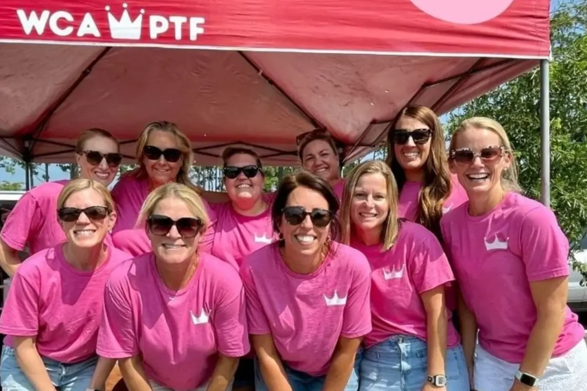 PTF volunteers in matching pink shirts under the WCA PTF tent at the Back to School Patriot Pops for Parents event
